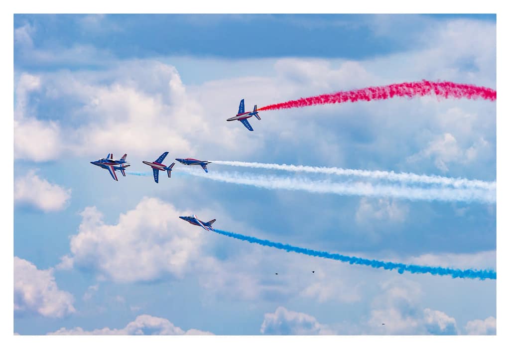 Avions de la Patrouille de France se séparant au milieu des fumées tricolores