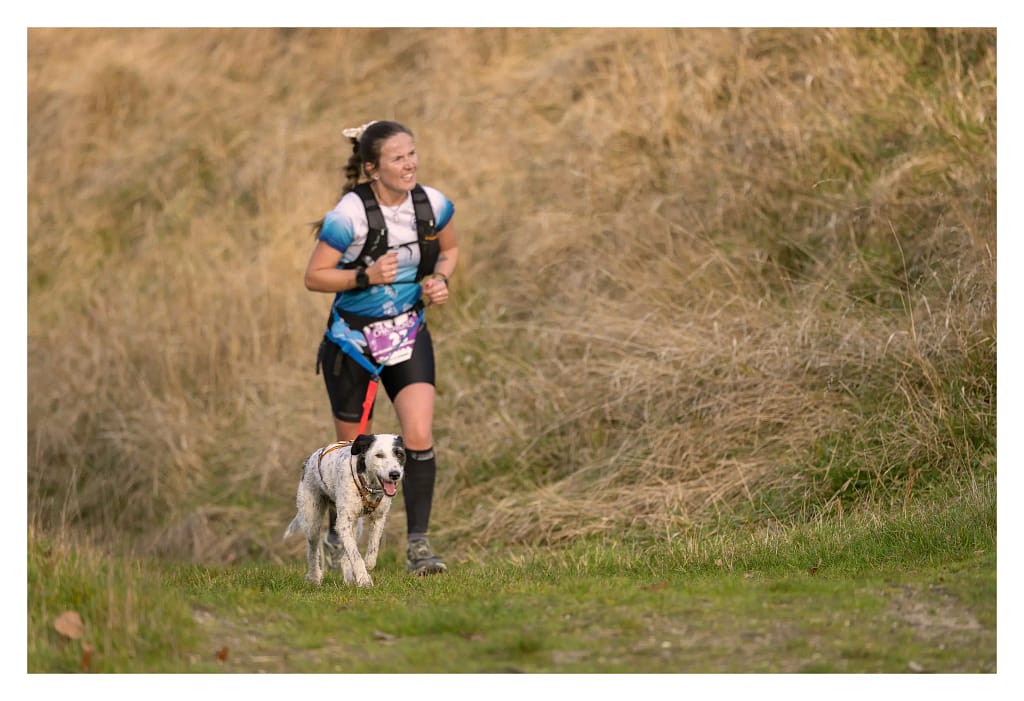 coureuse avec son chien au canitrail des châtaignes 2024 dans une montée