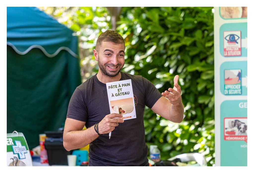 Samir Hrimach utilise une carte illustrée pendant un jeu de mémorisation sur les dangers pour les chiens et chats.