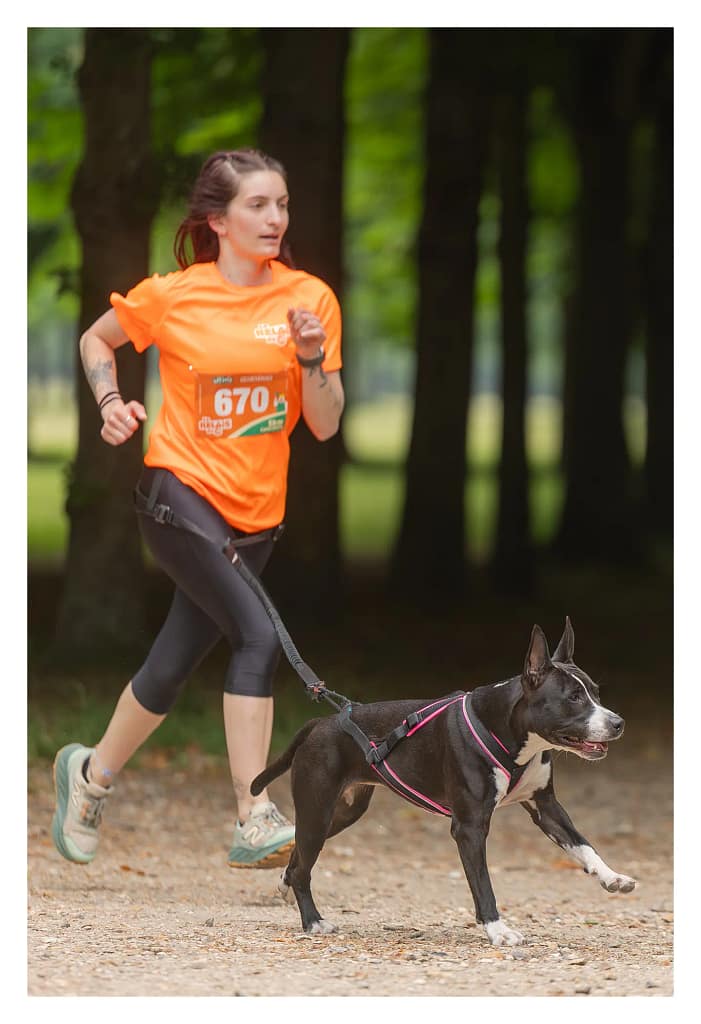 femme qui court avec son chien à l'épreuve de canicross pour le relais de la Spa